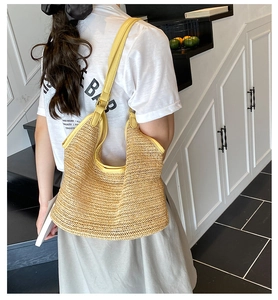Detail of yellow woven hobo bag showing crochet knit texture and faux leather shoulder strap