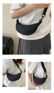 Detail of a black nylon crescent crossbody bag featuring an adjustable wide shoulder strap