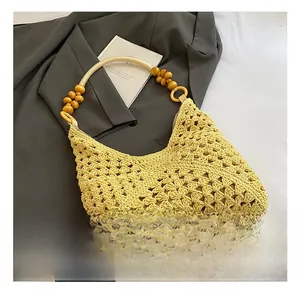 Detail view of yellow crochet tote bag featuring intricate hollow weave and wood bead handle