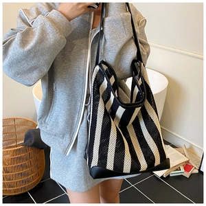 Black and white striped mesh tote bag shown on shoulder for large capacity daily use