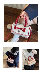 Detail of a mini Boston bag with red bow, heart charm and styling options