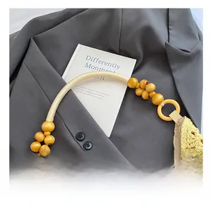 Detail of hollow woven bag featuring smooth wooden bead handle and yellow crochet texture