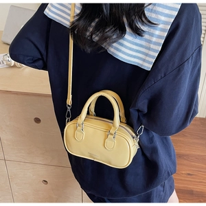 Detailed side view of a yellow leather Boston crossbody bag shown with a long strap
