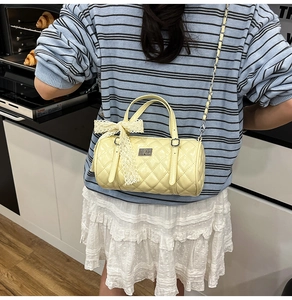 Détail du sac cylindre matelassé jaune clair avec nœud dans une cuisine moderne