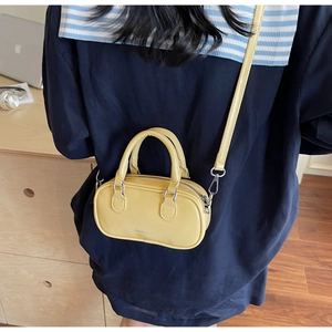Yellow Boston mini bag shown on model for size and cross-body style reference
