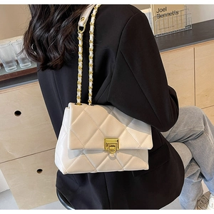 Détail du sac à bandoulière matelassé blanc cassé avec chaîne en cuir et métal doré