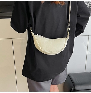 Detail of off-white crescent crossbody bag featuring lightweight crinkled fabric texture