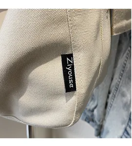 Detail of canvas tote bag showing the Ziyouse brand logo patch and coarse fabric texture