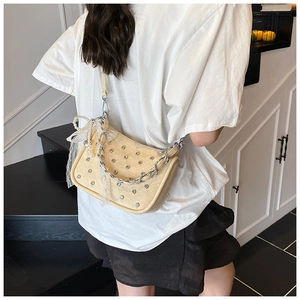 Détail du sac tressé à chaîne avec strass et breloque en dentelle de perles porté