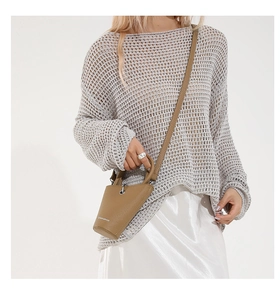 Vue détaillée d'un sac seau en cuir marron porté avec un haut en tricot gris et jupe