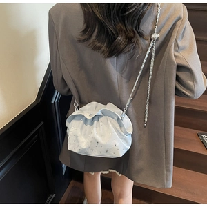 Detail of light blue pleated cloud bag featuring sparkling rhinestones and chain strap
