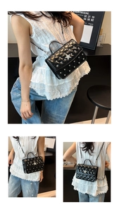 Détail du mini sac noir matelassé avec rivets argentés et étoile en strass sur la bandoulière