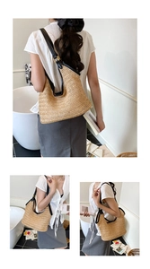 Detail of woven straw hobo bag featuring black leather trim and adjustable metal buckle