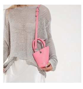 Détail du sac seau rose en cuir grainé avec finitions argentées et bandoulière