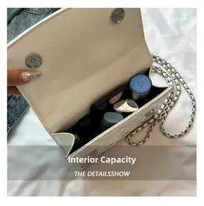 Macro view of white quilted chain bag interior showing capacity for phone and cosmetics