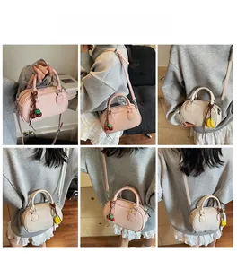 Detail of Boston handbag featuring lychee texture and cute fruit pendants in pink and beige