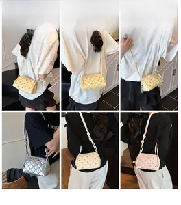 Detail view of quilted crossbody bag with metal rivets in beige, silver, and pink