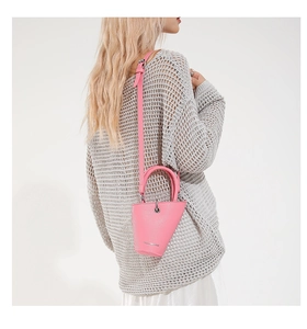 Détail du mini sac seau en cuir litchi rose avec lettrage de mode et poignée