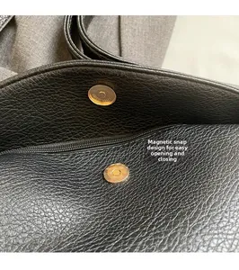 Macro shot of black lychee grain leather tote bag with magnetic clasp and gold hardware