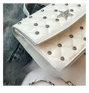 Detailed macro view of white quilted leather with crystal star and sparkling rhinestones