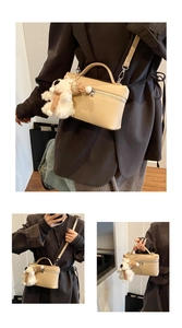 Dettaglio borsa quadrata beige con trama litchi e un simpatico ciondolo a forma di cane