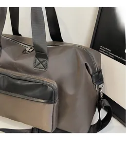 Detail view of water-resistant nylon fabric and metallic zippers on the travel bag