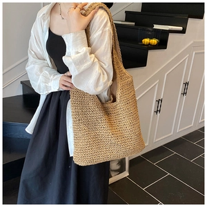 Dettaglio della trama di una borsa tote in paglia intrecciata a mano in fibra naturale