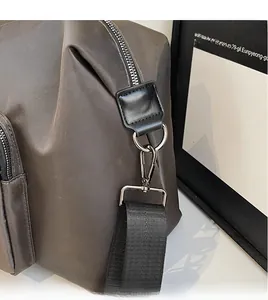 Close-up of durable gunmetal hooks and reinforced leather patches on a travel bag strap