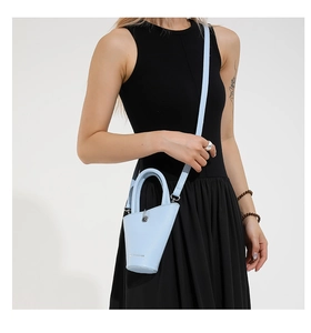 Vue détaillée du sac seau bleu clair avec texture grainée et logo de la marque