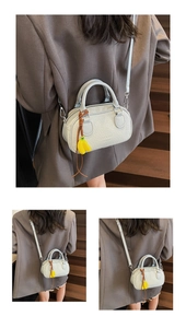 Detail of light blue Boston bag with stone texture leather and yellow banana charm decor