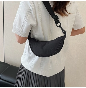 Chic black nylon crescent dumpling bag with adjustable strap worn by a model