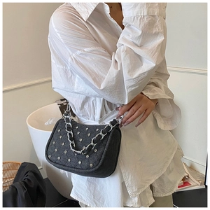 Détail du sac d'épaule en denim noir avec strass argentés et bandoulière chaîne