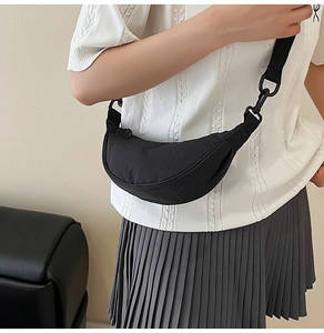 Detail showing high-quality black nylon half-moon bag with adjustable wide woven strap