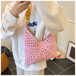Detalle del bolso de ganchillo rosa con correa de cuentas de madera y estilo bohemio