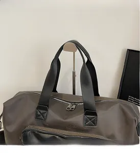 Close-up of durable dark grey travel bag with reinforced wide handles and silver zippers