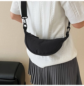 Minimalist black nylon crescent bag worn by model showing its ergonomic shoulder fit