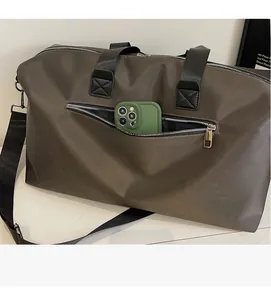 Front zipper pocket of a large travel bag showing quick access for a smartphone