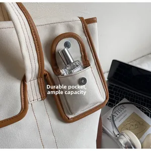 Détail du cabas en toile montrant une poche bordée de cuir et un espace de rangement utile