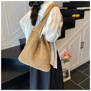 Detail of a large handmade woven straw tote bag with thick crochet texture and earthy tone