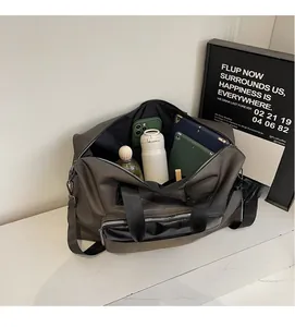 Top view of open travel bag showing spacious interior with tablet, phone, and water bottle