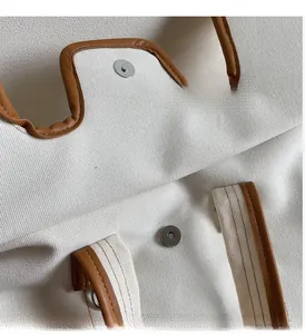 Détail du sac en toile avec bordure en cuir marron et boucle en métal magnétique argent