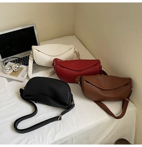 Detailed display of four crescent-shaped leather crossbody bags in various colors