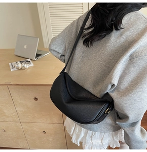 Detailed view of the black lychee pattern leather dumpling bag with gold hardware buckle