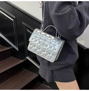Silver quilted mini bag with sparkling rhinestones and star detail on model shoulder