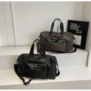 Macro detail of large travel bags in black and grey on marble display stands