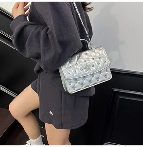 Détail du sac argenté matelassé avec étoile en strass et décorations cloutées