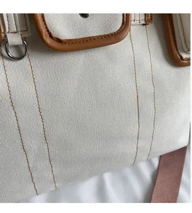 Détail de la texture en toile épaisse avec garniture en cuir brun et boucle en métal