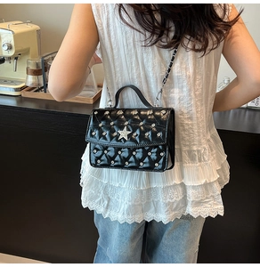 Details der schwarzen Stepptasche aus Leder mit silbernen Sternen und Metallkette