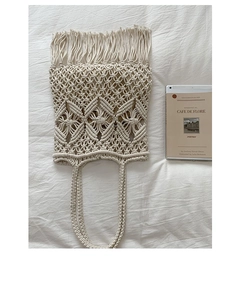 Detailed macro view of cream macrame tote bag featuring woven diamond patterns and tassels