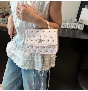 Detailed shot of pink quilted chain bag with silver star ornament and stud accents